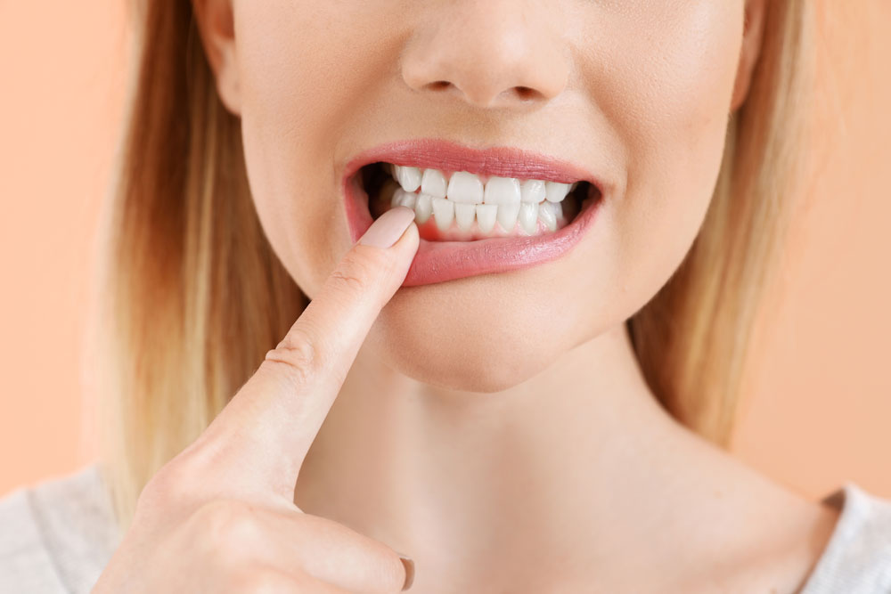A featured website image for emergency dentist in belleville featuring a woman pointing at her mouth