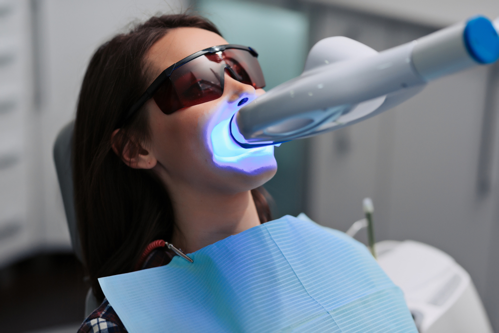teeth whitening procedure with ultraviolet light uv lamp in dental clinic