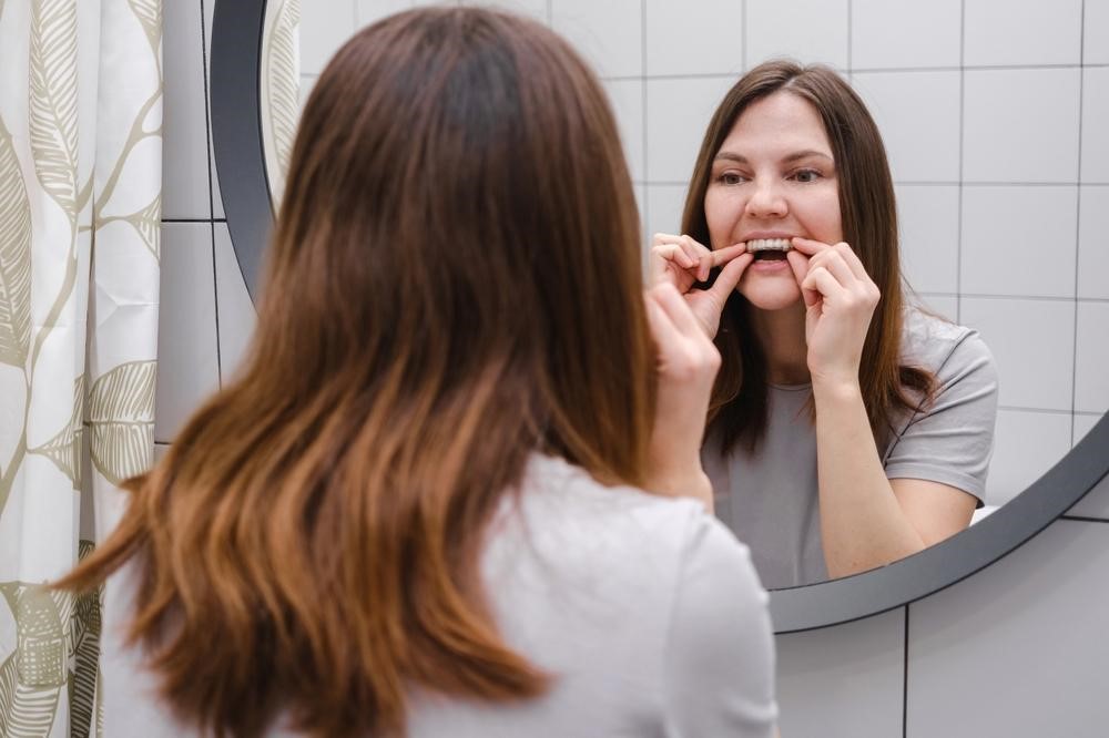 woman front mirror bathroom holding invisible