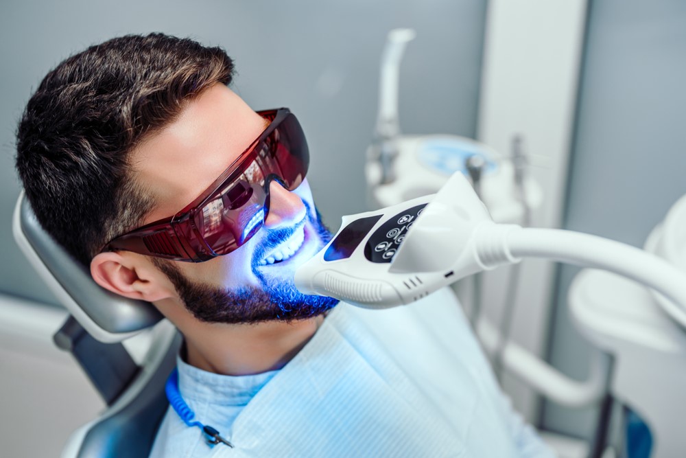 A young man gets his teeth professionally whitened