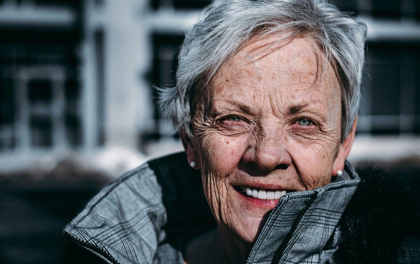 Older woman with short gray hair smiling at camera